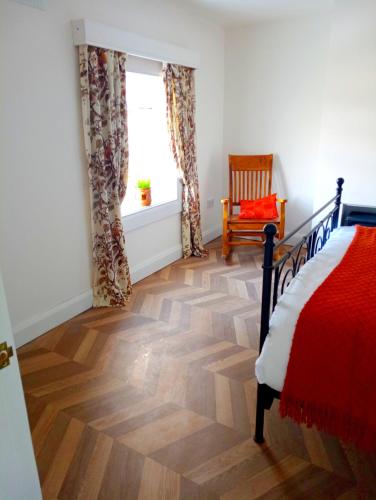 a bedroom with a wooden floor and a bed and a window at Donegal cottage in Donegal