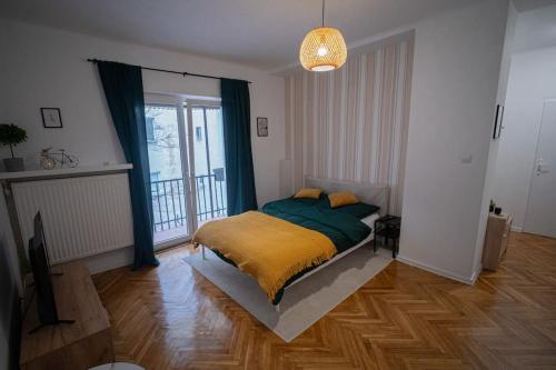 1 dormitorio con 1 cama con manta amarilla en Smulikowskiego Apartment en Varsovia