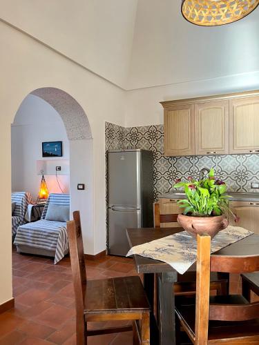 a kitchen and dining room with a table and a refrigerator at Dammuso U Granatu in Pantelleria