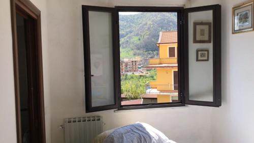 ein Fenster in einem Zimmer mit Blick auf ein Gebäude in der Unterkunft CASA VACANZE ROSA BLU in Giffoni Valle Piana