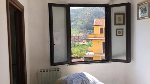 - une fenêtre dans une chambre avec vue sur un bâtiment dans l'établissement CASA VACANZE ROSA BLU, à Giffoni Valle Piana