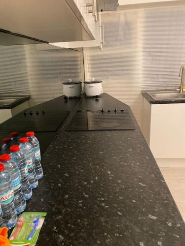 a kitchen with bottles of water on a counter at (023) Lovely 2 bedroom house London in London