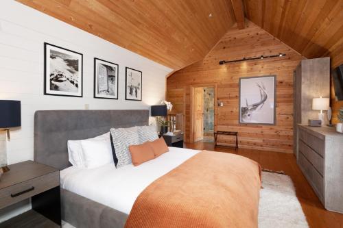 a bedroom with a large bed and wooden walls at Pinnacle Ridge 34 - Ski In Ski Out, Private Hot Tub, Recently Renovated, Gas Fireplace in Whistler