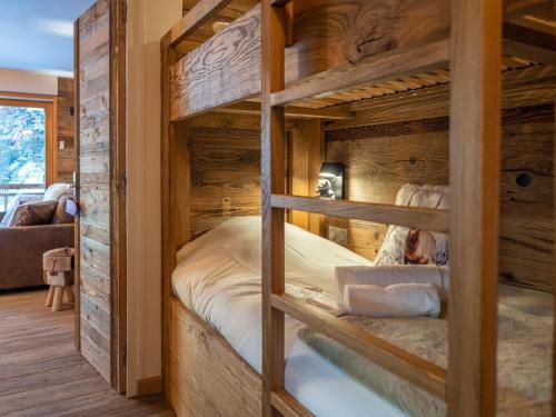 a bedroom with bunk beds in a log cabin at Appartement rénové au cœur de l'Alpe d'Huez avec Wifi et Parking - FR-1-645-24 in LʼHuez