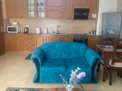 a living room with a blue couch in a kitchen at Guest House Fier in Fier