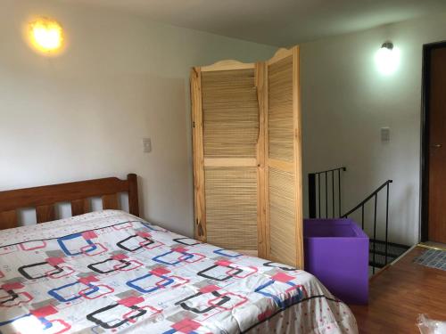 1 dormitorio con cama y armario de madera en Quilmeña-al-Sur Departamento 1 en Esquel