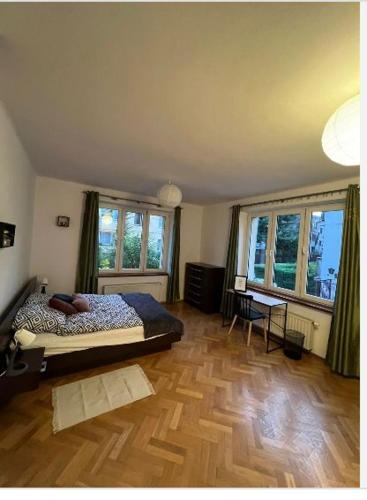 a bedroom with a bed and a wooden floor at Cheerful 3 bedroom city house in Krakow