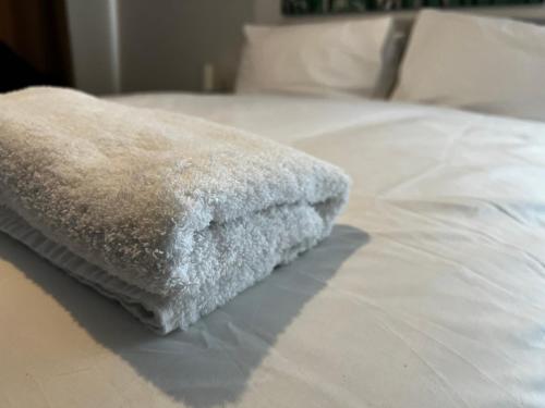 a white towel sitting on top of a bed at Luxury Suites near Wembley Stadium, Wembley Arena, London Designer Outlet in London