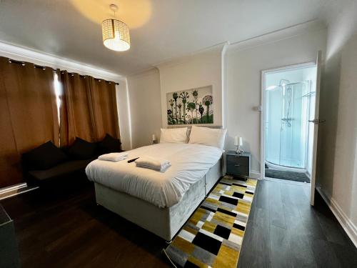 a small bedroom with a bed and a couch at Luxury Suites near Wembley Stadium, Wembley Arena, London Designer Outlet in London