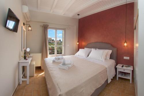 a bedroom with a large bed with two towels on it at Magnolia Apartments in Fiskardho