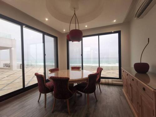 a dining room with a table and chairs and windows at Wadi Shab/Fins Villa in Fins