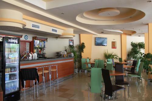 a restaurant with a bar and tables and chairs at Hotel Energy in Kiten