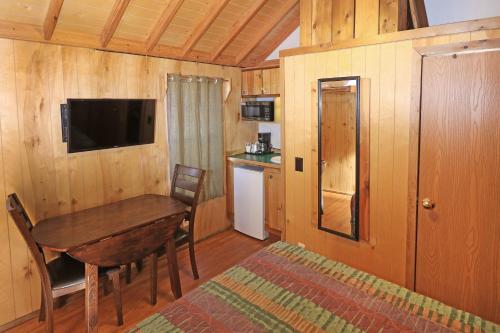 a dining room with a wooden table and a television at Sun Outdoors Arches Gateway in Moab
