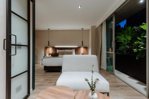 a bedroom with a bed and a white couch at 1616 Hotel in Medellín