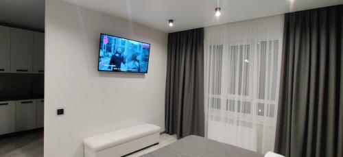 uma sala de estar com televisão na parede em Стильні апартаменти Атлант em Lutsʼk