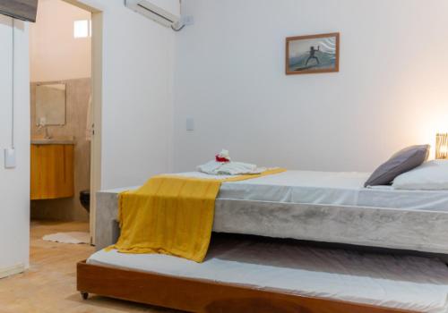 ein Schlafzimmer mit einem Bett mit einer gelben Decke darauf in der Unterkunft casa jasmin in Jericoacoara