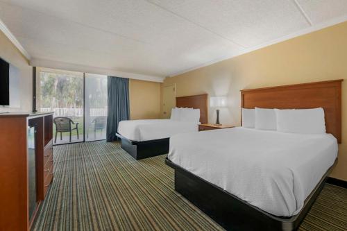 a hotel room with two beds and a television at Best Western International Speedway Hotel in Daytona Beach