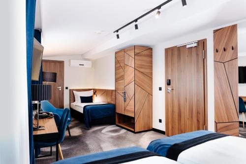 Habitación de hotel con 2 camas y escritorio en Ascot Premium Hotel, en Cracovia