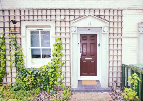 dom z brązowymi drzwiami i oknem w obiekcie 2 Bed Camden Mews w Londynie