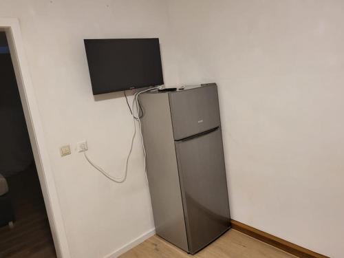 einen kleinen Kühlschrank mit einem Flachbild-TV an der Wand in der Unterkunft Traumferienwohnung in Bad Friedrichshall in Bad Friedrichshall