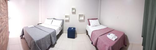 a room with two beds in a room at Hotel Enlace in Ji-Paraná