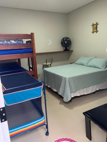 um quarto com uma cama e um beliche com uma escada em Casa bem aconchegante! em Ubatuba