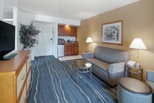 a living room with a couch and a kitchen at Ramada by Wyndham Costa Mesa/Newport Beach in Costa Mesa