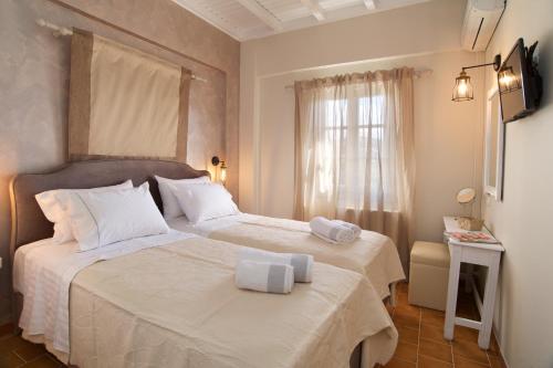 a hotel room with two beds and a window at Magnolia Apartments in Fiskardho