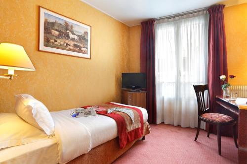 a hotel room with a bed and a desk and a window at Hotel Paix Republique in Paris
