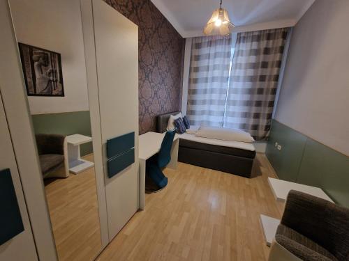 ウィーンにあるAparthotel LAAERBERGのベッドと窓が備わる小さな客室です。