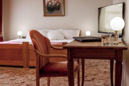 a bedroom with a desk with a laptop and a bed at Palazzo Adler Swarzędz in Swarzędz