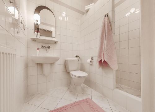 ein weißes Bad mit einem WC und einem Waschbecken in der Unterkunft Adler in Swarzędz