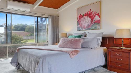 a bedroom with a bed and a large window at 41 Collins Street Merimbula in Merimbula