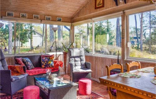 a screened in porch with chairs and a table at Stunning Home In Borrby With Wifi in Borrby