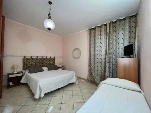 - une chambre avec 2 lits et une télévision dans l'établissement Lupa Di Mare Casa Vacanze, à Otrante