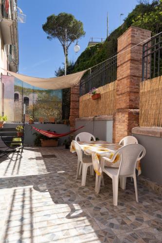 a patio with a table and chairs and a swing at PALAZZO PELLEGRINO vietri in Vietri sul Mare