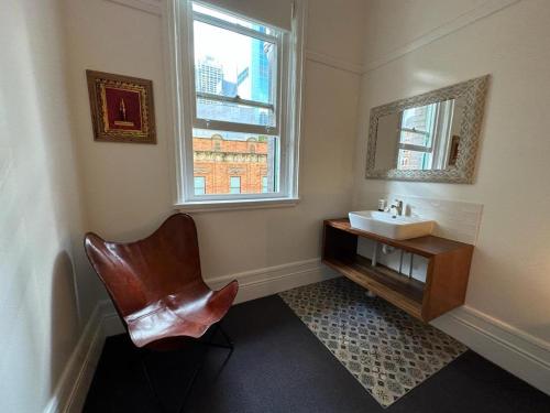 a bathroom with a sink and a chair and a mirror at The Resch House in Sydney