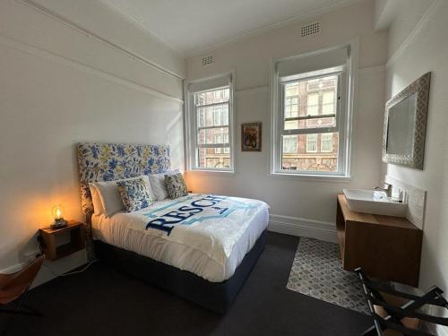 1 dormitorio con 1 cama, lavamanos y 2 ventanas en The Resch House, en Sídney