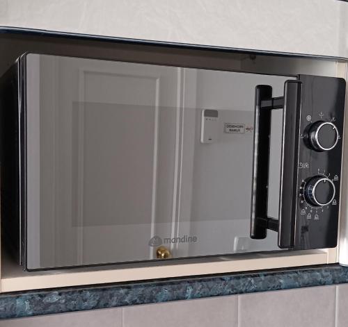 a microwave oven with a glass door in a kitchen at Benaldream in Benalmádena