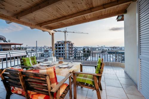a patio with a table and chairs on a balcony at Penthouse of diamond in Athens