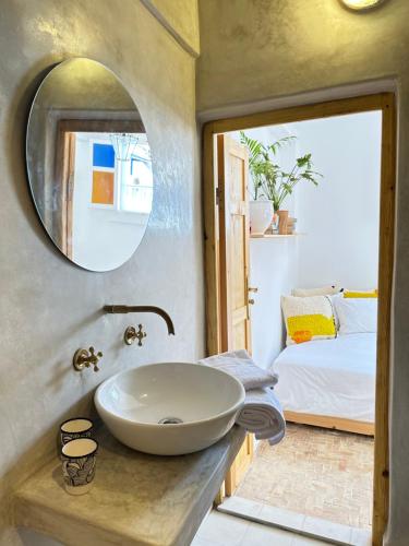 a bathroom with a sink and a bedroom at Home with a sea view in Essaouira