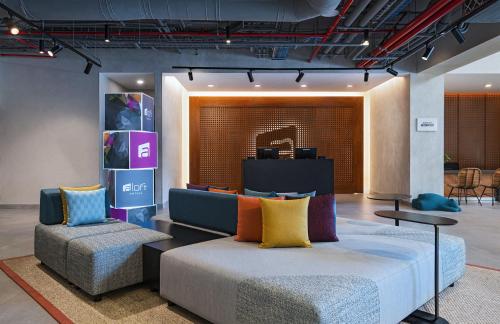 a living room with a couch and two chairs at Aloft Playa del Carmen in Playa del Carmen