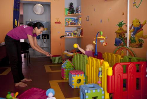 a woman playing with a baby in a room at Kenzi Club Agdal Medina - All Inclusive in Marrakesh