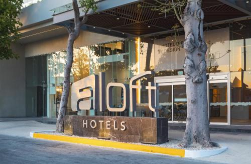 a hotel sign in front of a building at Aloft by Marriott Playa del Carmen in Playa del Carmen