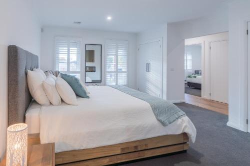 um quarto branco com uma cama grande e almofadas em Yarra Valley Escape em Healesville