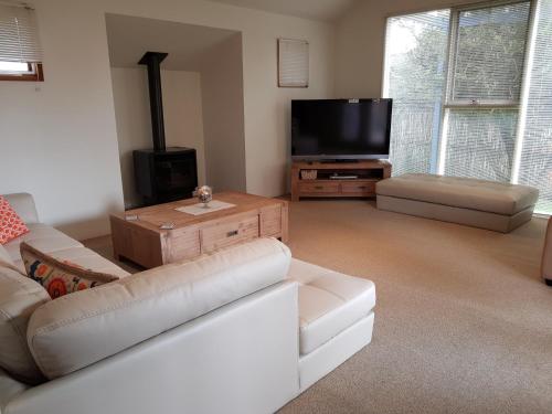 a living room with a couch and a flat screen tv at Lonsdale Shores in Point Lonsdale