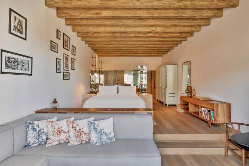 a living room with a bed and a couch at Live Aqua San Miguel de Allende in San Miguel de Allende
