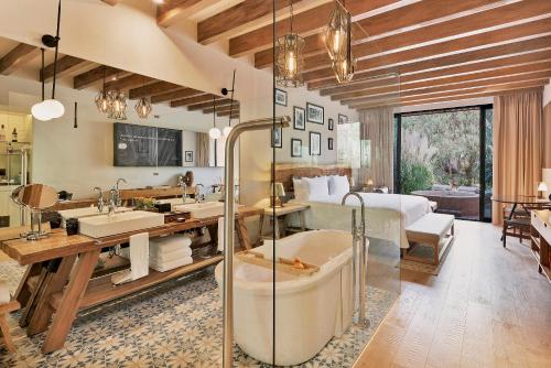 a bathroom with a bed and a tub in a room at Live Aqua San Miguel de Allende in San Miguel de Allende