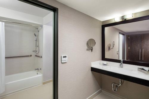 a bathroom with a sink and a shower and a mirror at Courtyard New York Manhattan/Times Square in New York