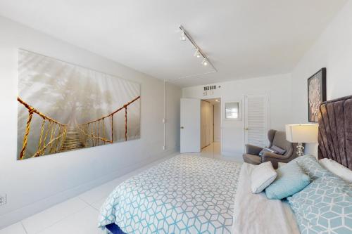 a bedroom with a bed and a painting on the wall at Decoplage Paradise - Unit B in Miami Beach